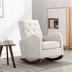 a white rocking chair sitting on top of a rug