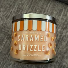 an orange and white striped jar with caramel drizzle on it's lid