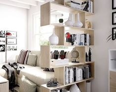 a living room filled with lots of furniture and bookshelves next to a window