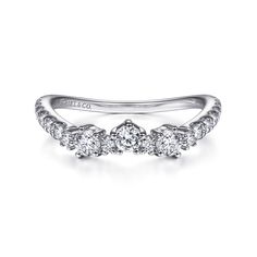 a three stone diamond ring in white gold with diamonds on the band and side stones