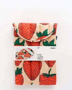 an orange and white bag with strawberries printed on the front, sitting on a white surface