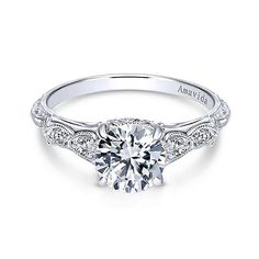 an 18k white gold engagement ring with a round diamond center