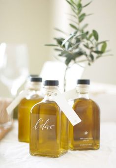 three bottles of olive oil sitting on top of a table