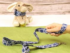 a person holding onto a blue and white ribbon with a stuffed animal in the background