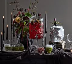 a table with candles, vases and glasses on it