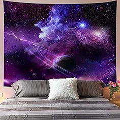 an image of a space themed wall hanging in a bedroom with a bed and pillows