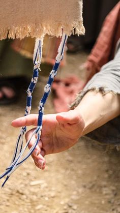 a person holding something in their hand with ropes attached to it's wrist,