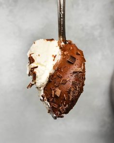 a piece of cake on a fork with ice cream and chocolate shaving in it