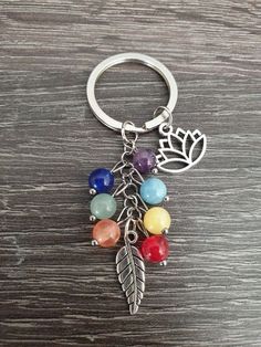 a keychain with seven chakraa beads and a leaf charm on it