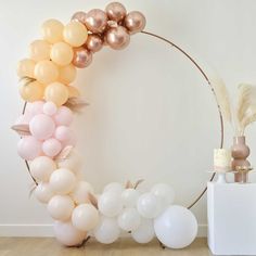 the balloon arch is decorated with gold, white and pink balloons