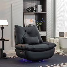 a living room with a black leather reclining chair and blue light on the floor