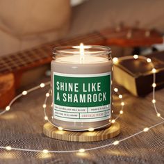 a candle sitting on top of a table next to a string of lights and a guitar