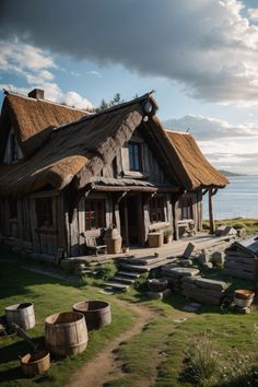 an old wooden house with thatched roof next to the ocean