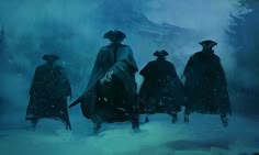 three people in cloaks walking through the snow