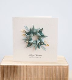 an origami christmas card on top of a wooden box