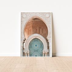 an arch in the middle of a room with wood flooring and white wall behind it