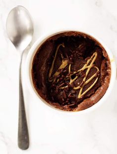 a chocolate dessert in a white bowl with spoon