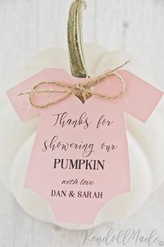 a pink and white pumpkin with a tag on it