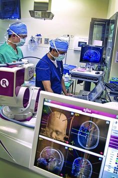 two doctors in scrubs are operating on an x - ray