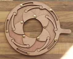 a circular object made out of wood on top of a wooden table with metal rivets