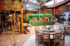 an indoor restaurant with tables and chairs set up for people to sit at the table