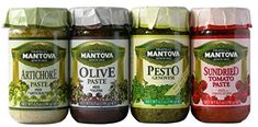 five jars of pesto and other condiments are lined up in a row