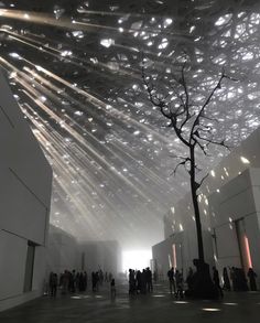 people are standing in the middle of a large room with lights coming from the ceiling