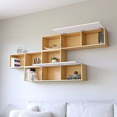 a white couch sitting next to a wall mounted shelf