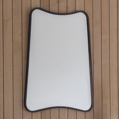 a close up of a mirror on a wooden wall with wood planks in the background