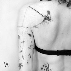 the back of a woman's body with tattoos on it