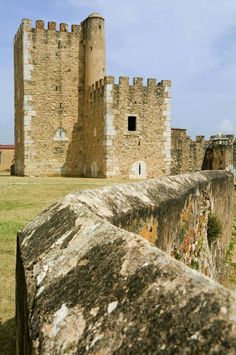 an old stone castle sitting on top of a lush green field