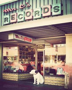 a store front with a dog statue outside