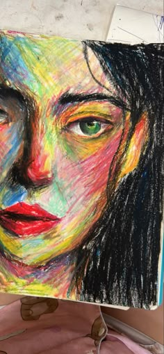 a drawing of a woman's face is shown in colored pencils on a piece of paper