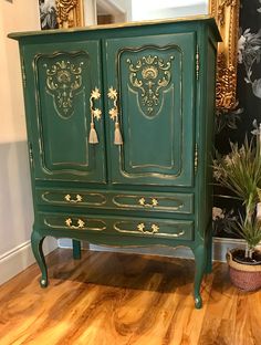 a green armoire with ornate designs on it