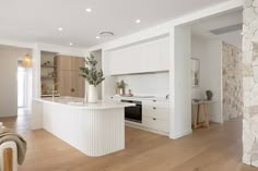 an open kitchen with white cabinets and wood flooring is featured in this image from the inside