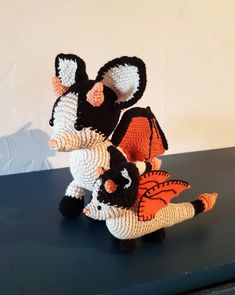 three crocheted stuffed animals sitting on top of a black table next to each other