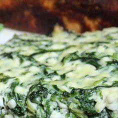 spinach and cheese pizza on a plate with other food items in the back ground