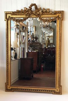 a large gold framed mirror sitting on top of a table