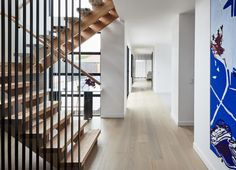 a long hallway with wooden stairs and handrails leading up to the second floor