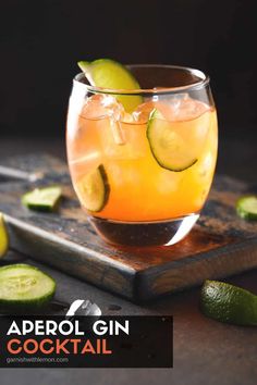 an alcoholic cocktail in a glass with cucumber garnish on the side