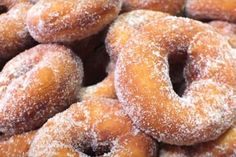 a pile of sugar covered donuts sitting next to each other