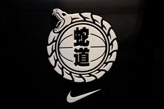 the nike logo with chinese writing and a snake on it's head in front of a black background