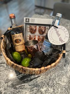 a basket filled with liquor and other items on top of a marble countertop next to a bottle of booze