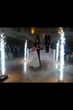 a bride and groom dancing with sparklers in the air