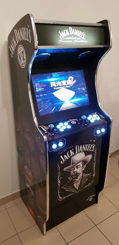 a jack daniels arcade machine sitting on top of a tile floor next to a wall