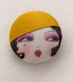 a close up of a small button with a woman's face on the front