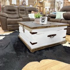 a white box sitting on top of a black rug in a living room filled with furniture