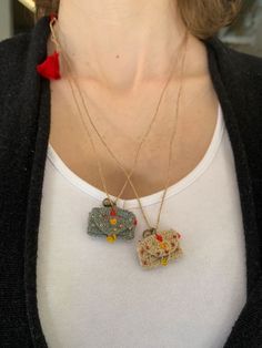 a close up of a person wearing a necklace with two pendants attached to it