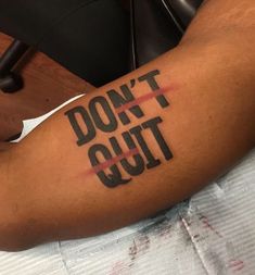 a person with a tattoo on their arm that says don't quit