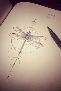 a drawing of a dragonfly sitting on top of a piece of paper next to a pen